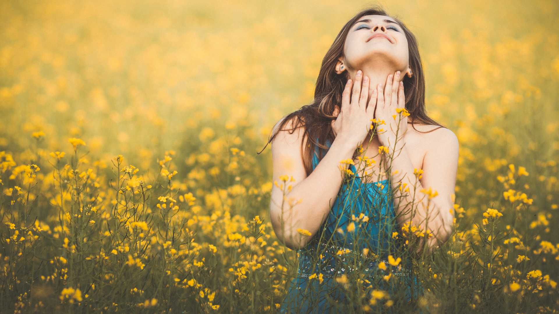 femme dans un champ de fleur jaune