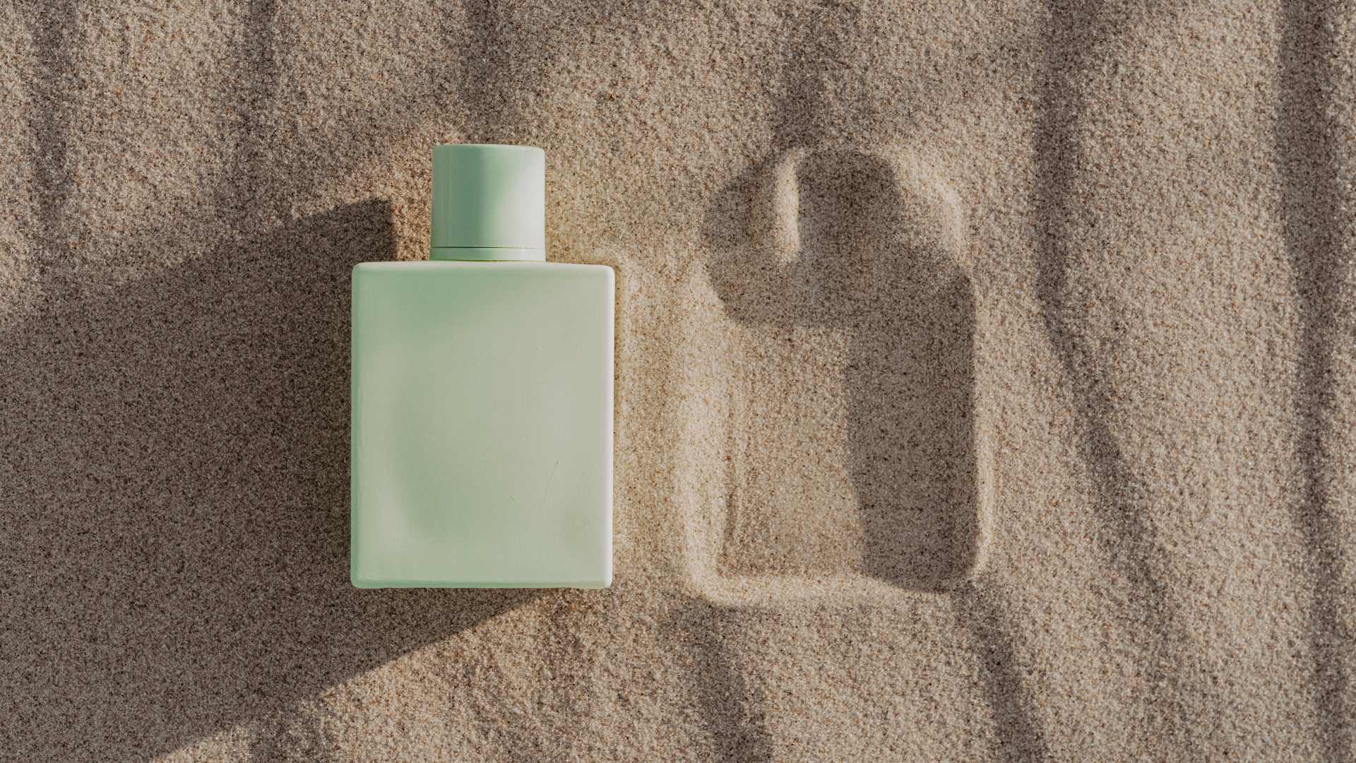 flacon de parfums sur le sable
