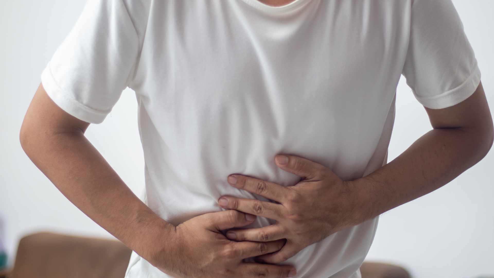 Homme qui se tient le ventre de douleur